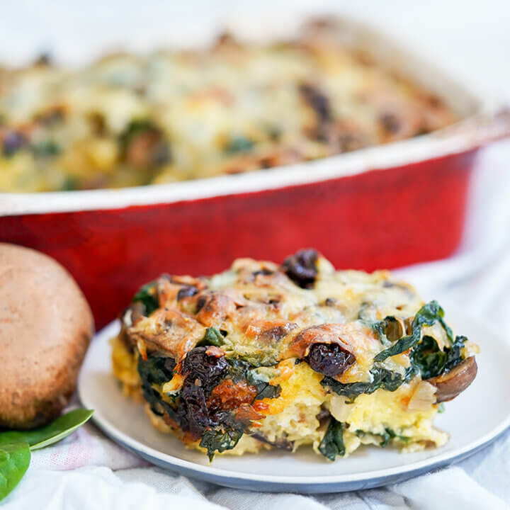 slice of vegetable strata on plate with dish blurred behind.