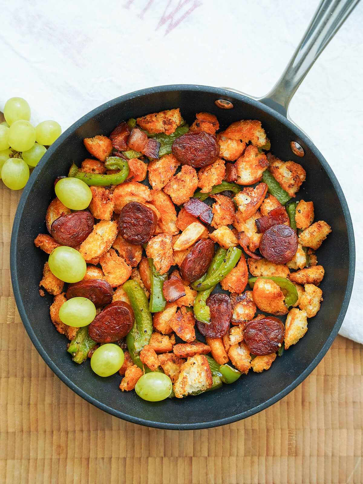 overhead view of skillet of Spanish migas with grapes to side.