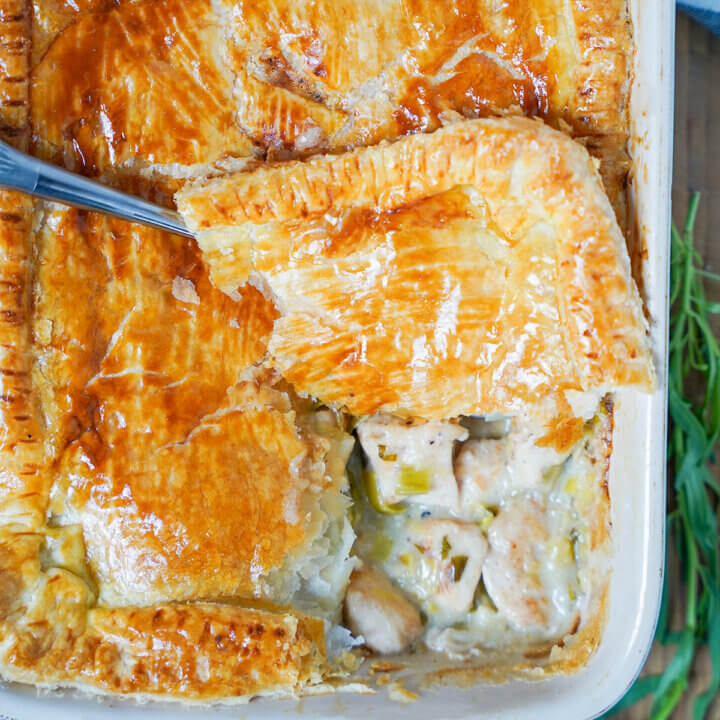 corner pastry of chicken and leek pie with tarragon on top pie showing filling below.