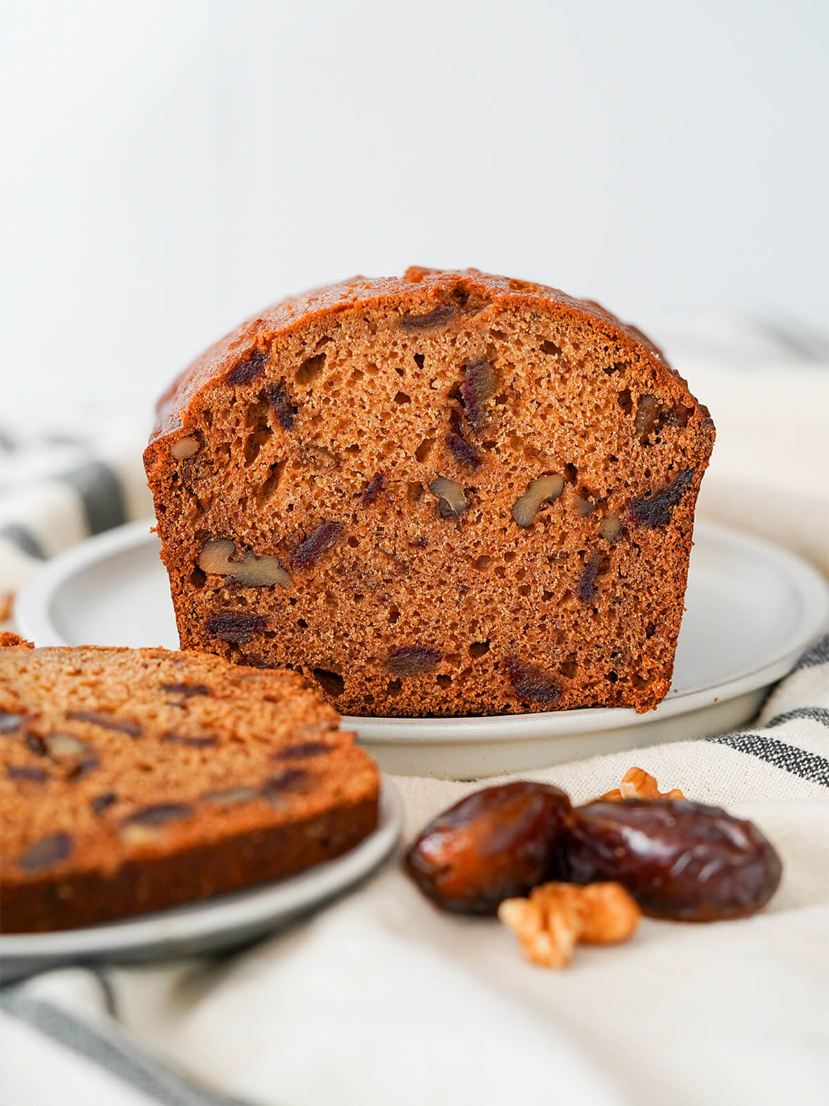 end on view of date and walnut loaf with partial slice in front.
