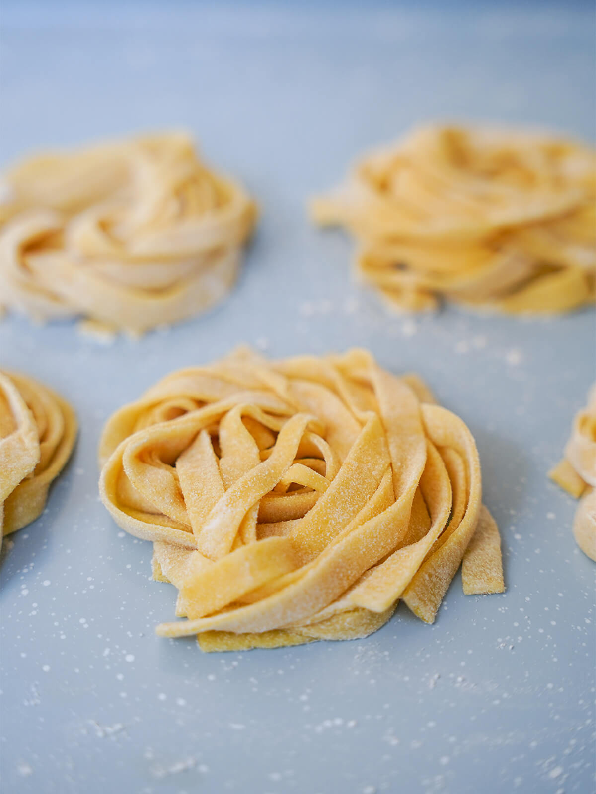 stacks of fresh pumpkin pasta dough noodles on tray stacks of fresh pumpkin pasta dough on tray.