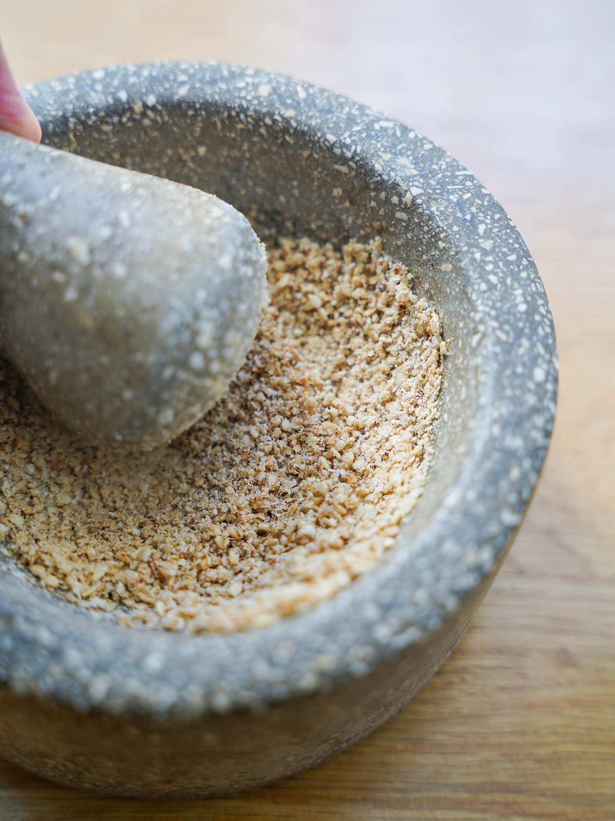grinding toasted sesame seeds with pestle and mortar.