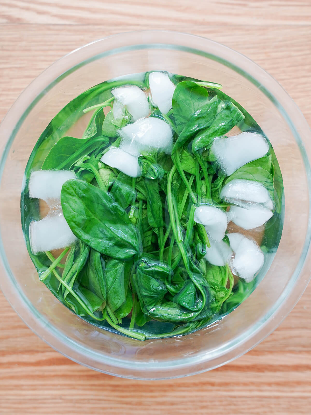 wilted spinach in bowl of iced water.