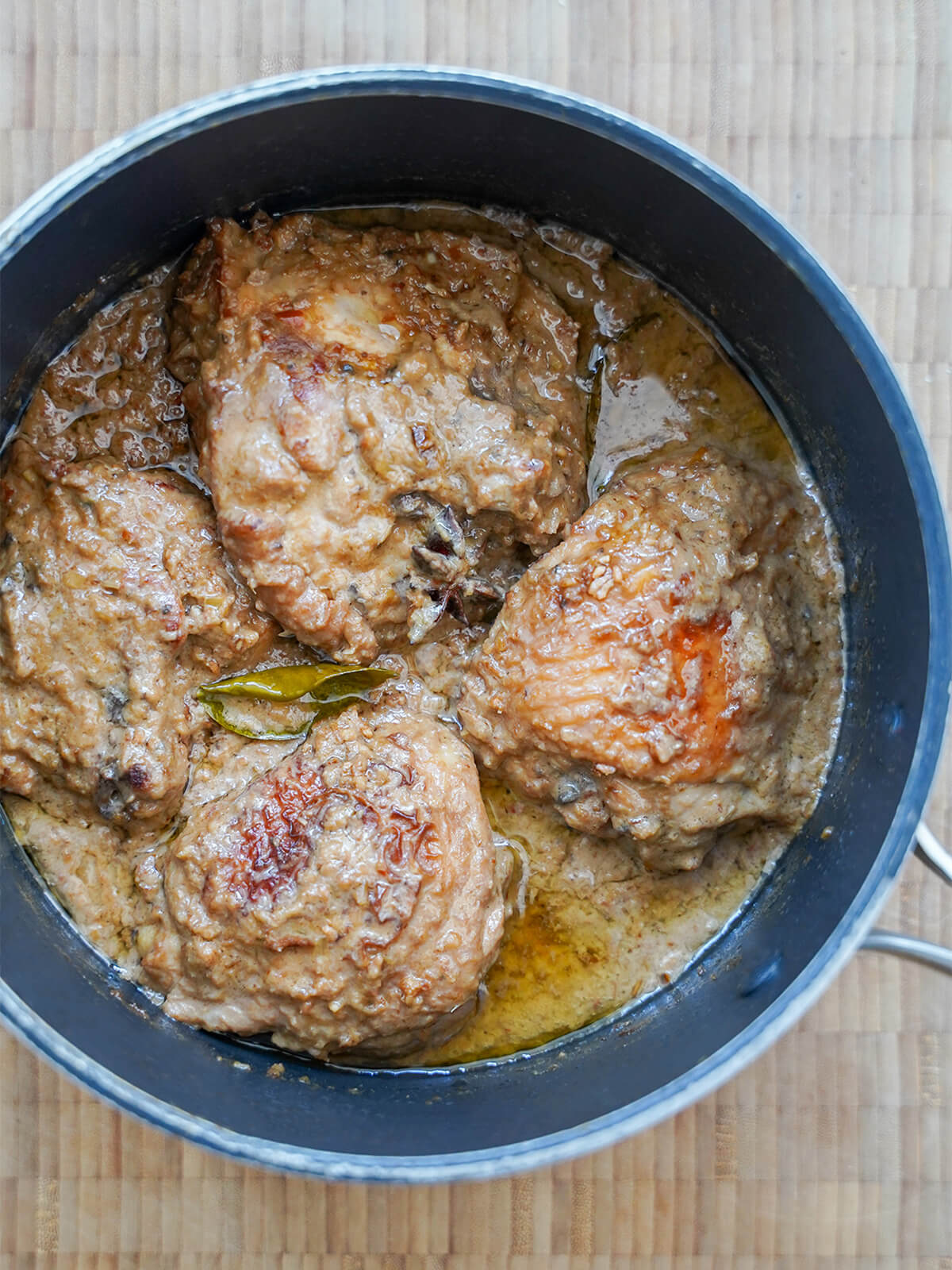overhead view of pot of chicken rendang ater simmer showing oil separation on top.