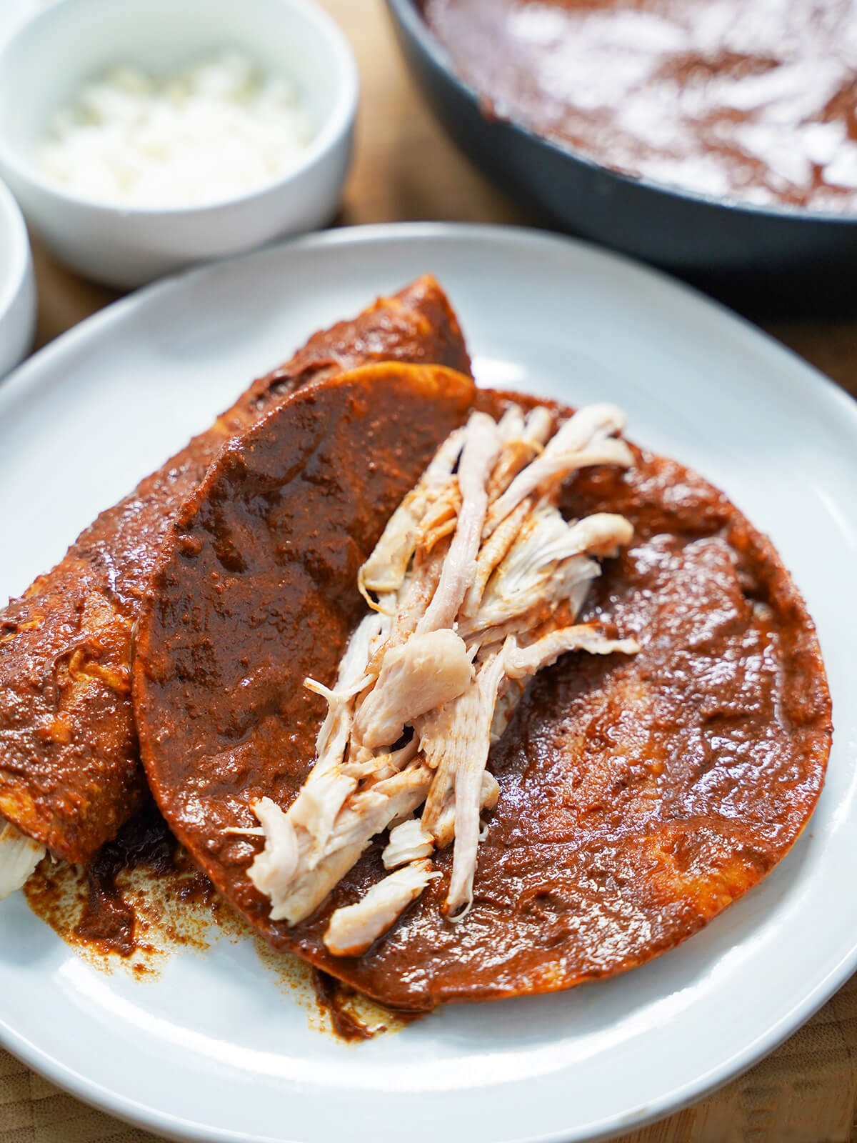 chicken on mole-coated tortilla shredded chicken on top of a mole-dipped tortilla before folding.