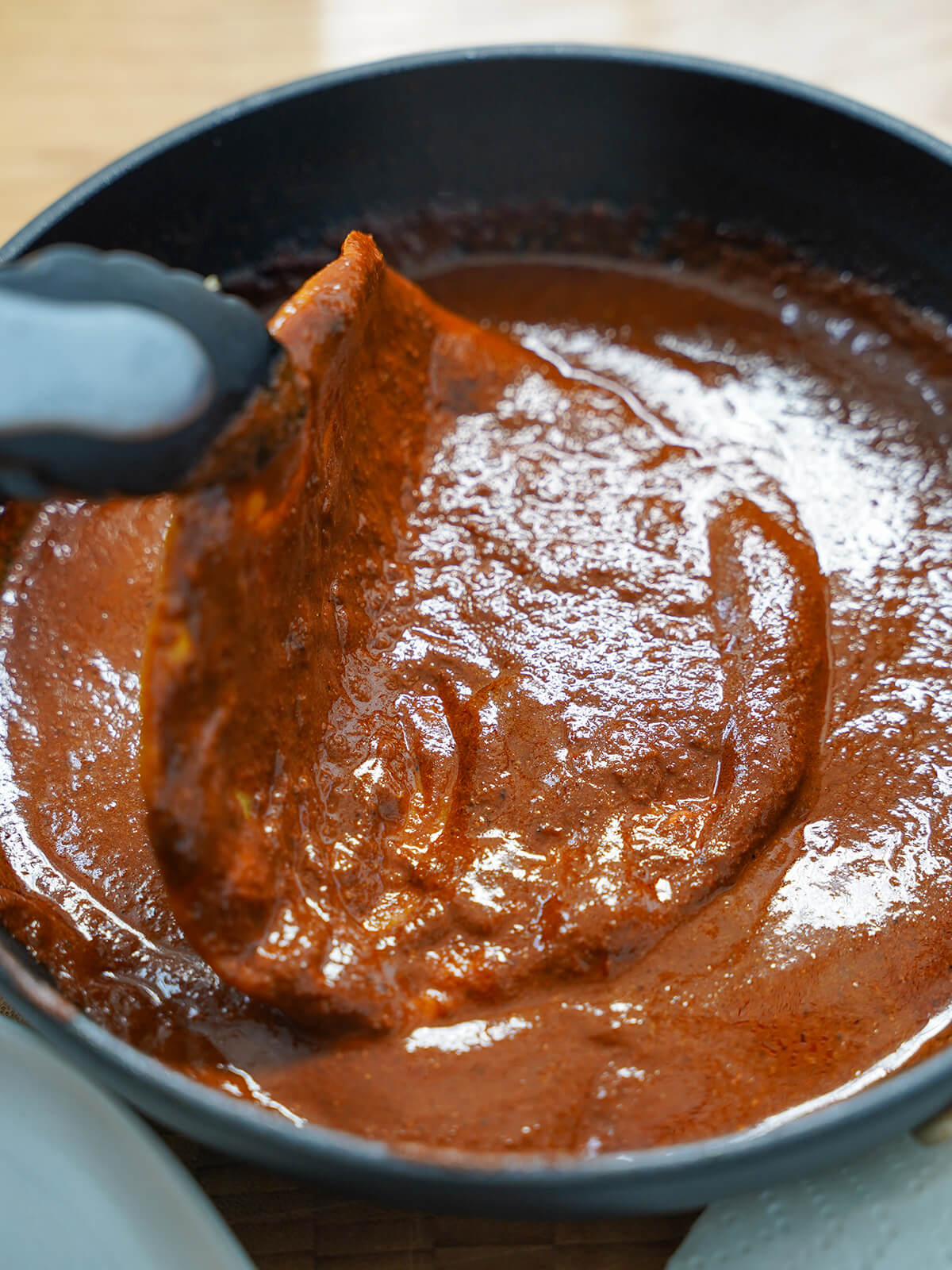 dipping tortilla in mole for enmoladas dipping a tortilla in mole sauce.