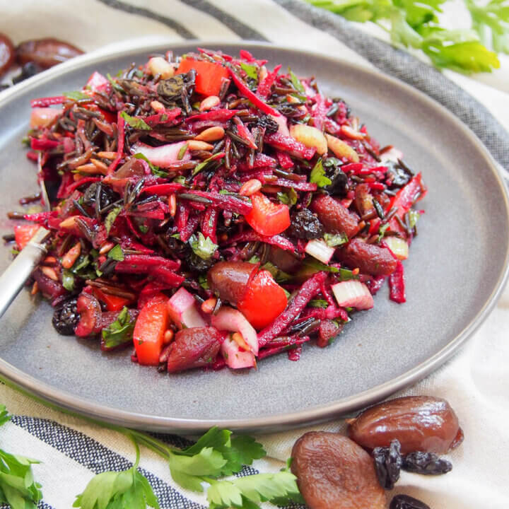 wild rice salad with dried fruit on grey plate.