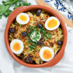 dish of Bacalhau à Gomes de Sá, Portuguese salt cod, from overhead topped with olives and egg.