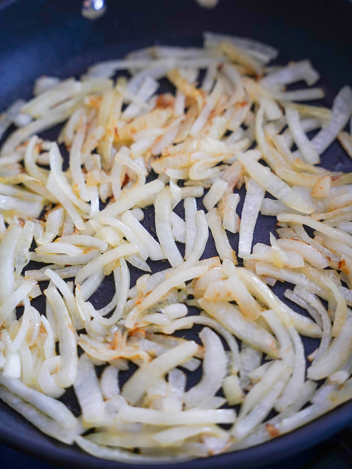 cooking sliced onions in skillet to gently brown