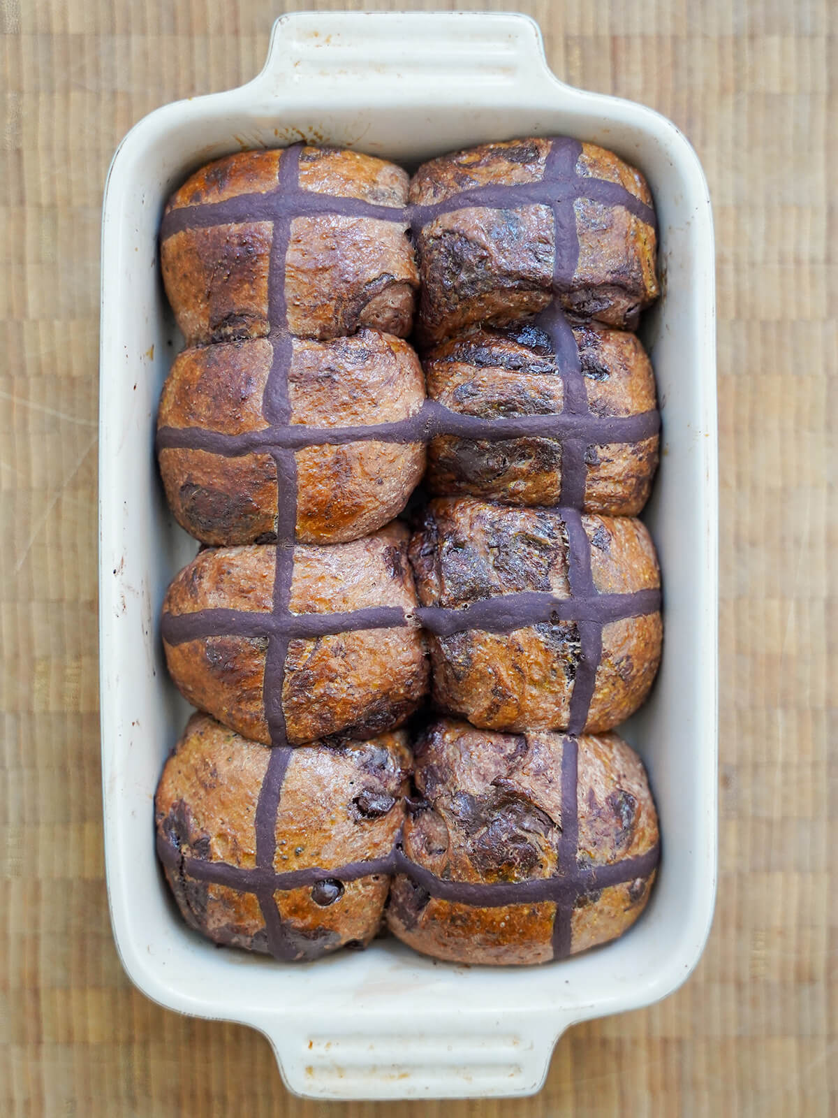 baking dish with chocolate hot cross buns in it.