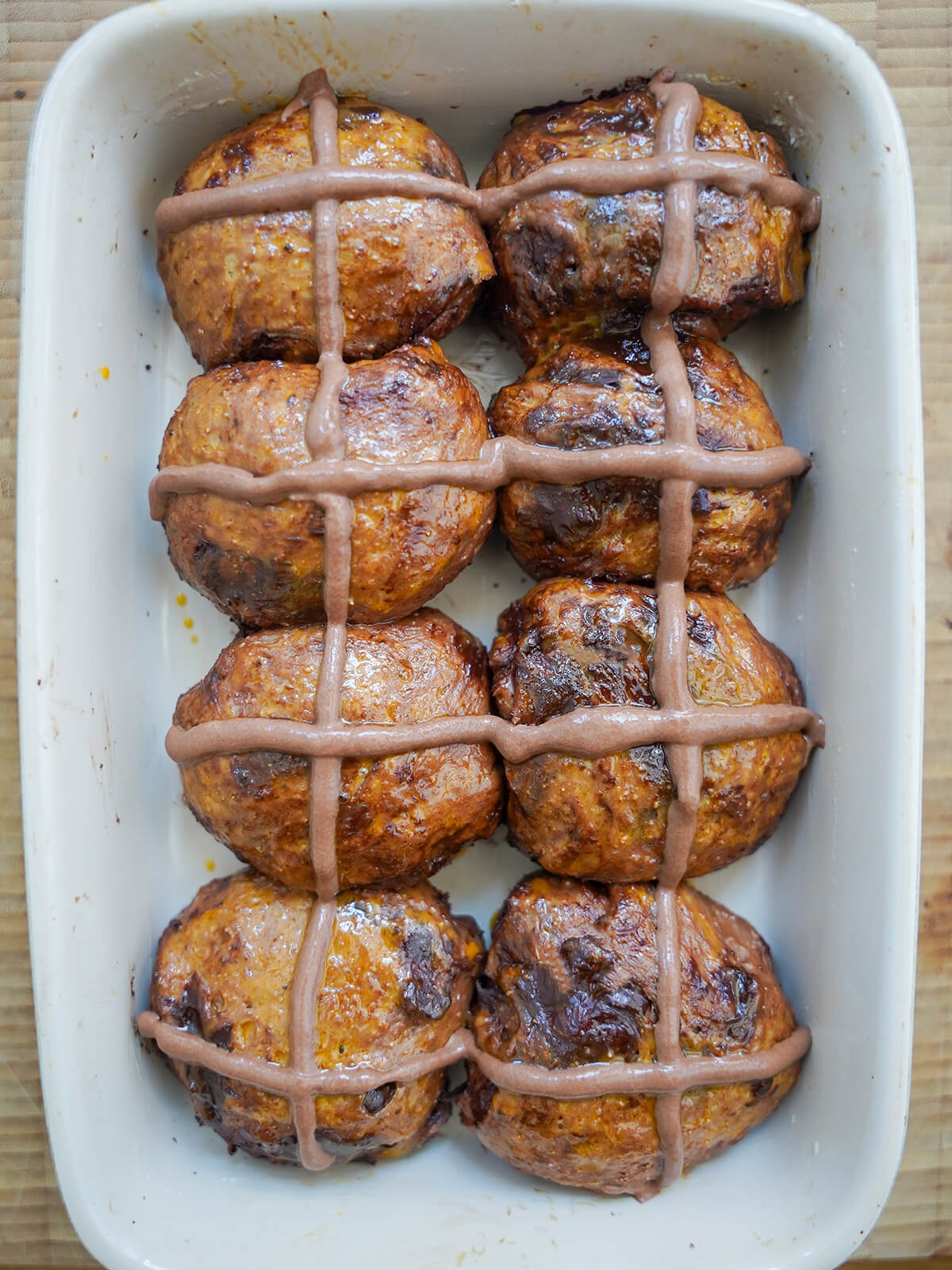 formed chocolate hot cross buns with flour paste piped on top before baking.