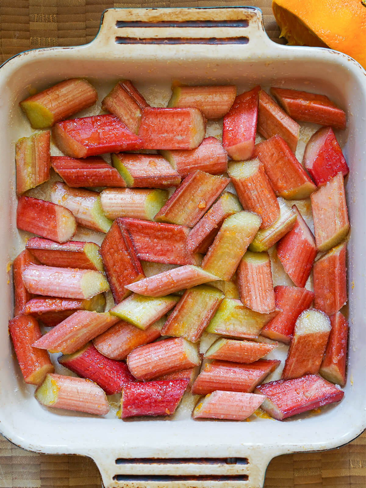 chunks of rhubarb in baking dish, tossed with sugar, before cooking.