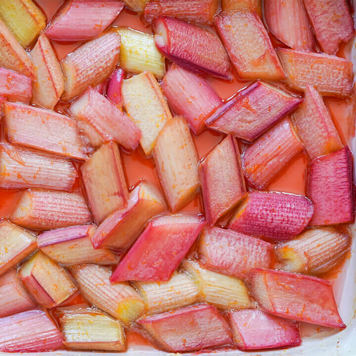 close up of roasted rhubarb in pinky syrup in dish.