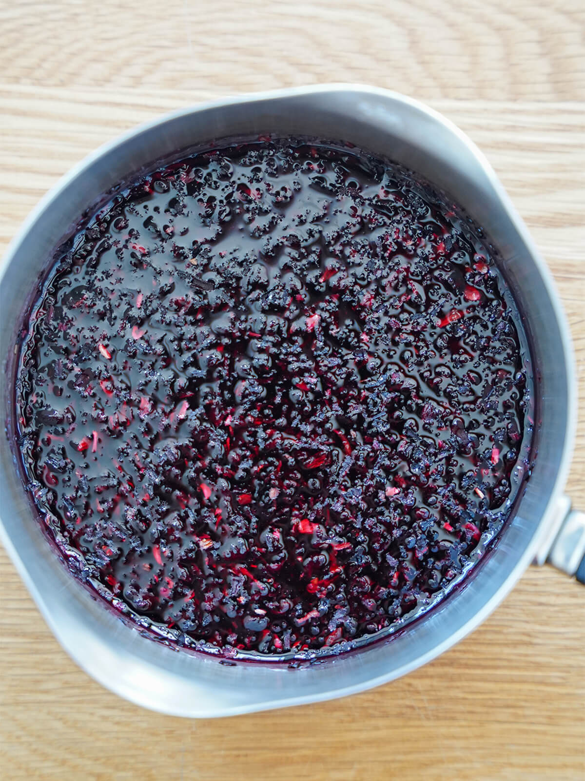 pan with hibiscus flowers steeping in water.