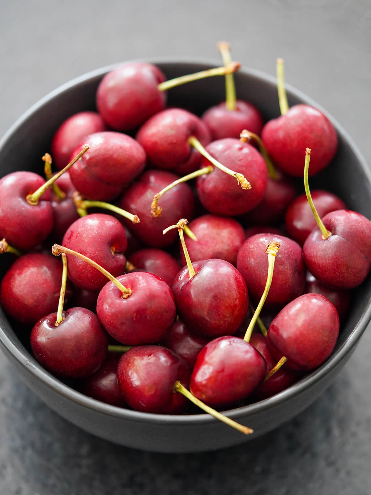 bowl of cherries in grey bowl.