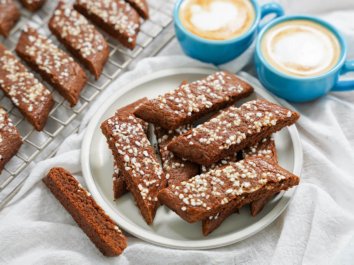 side view of chokladsnittar, Swedish chocolate cookies stacked on a plate.