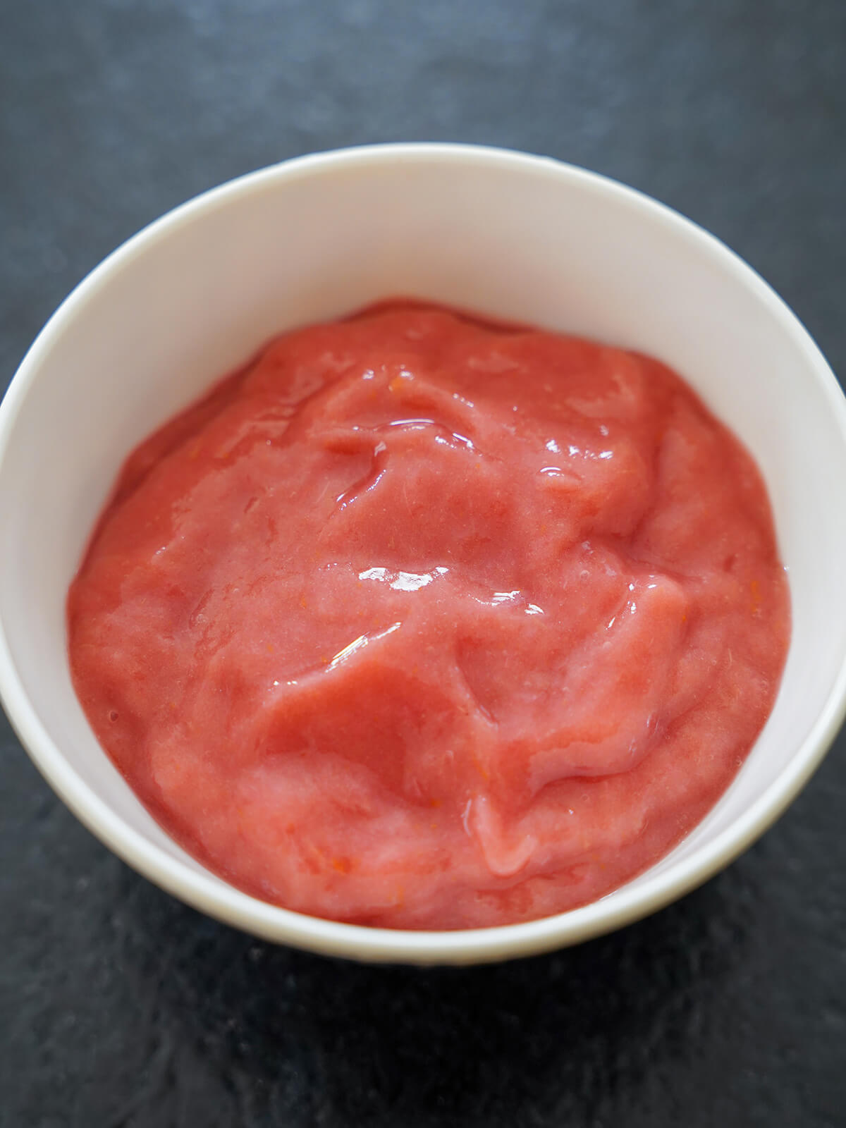 bowl filled with pink rhubarb puree.