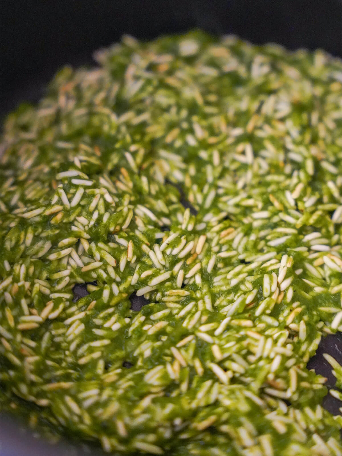 toasted rice with herby paste mixed in in bottom of pan.