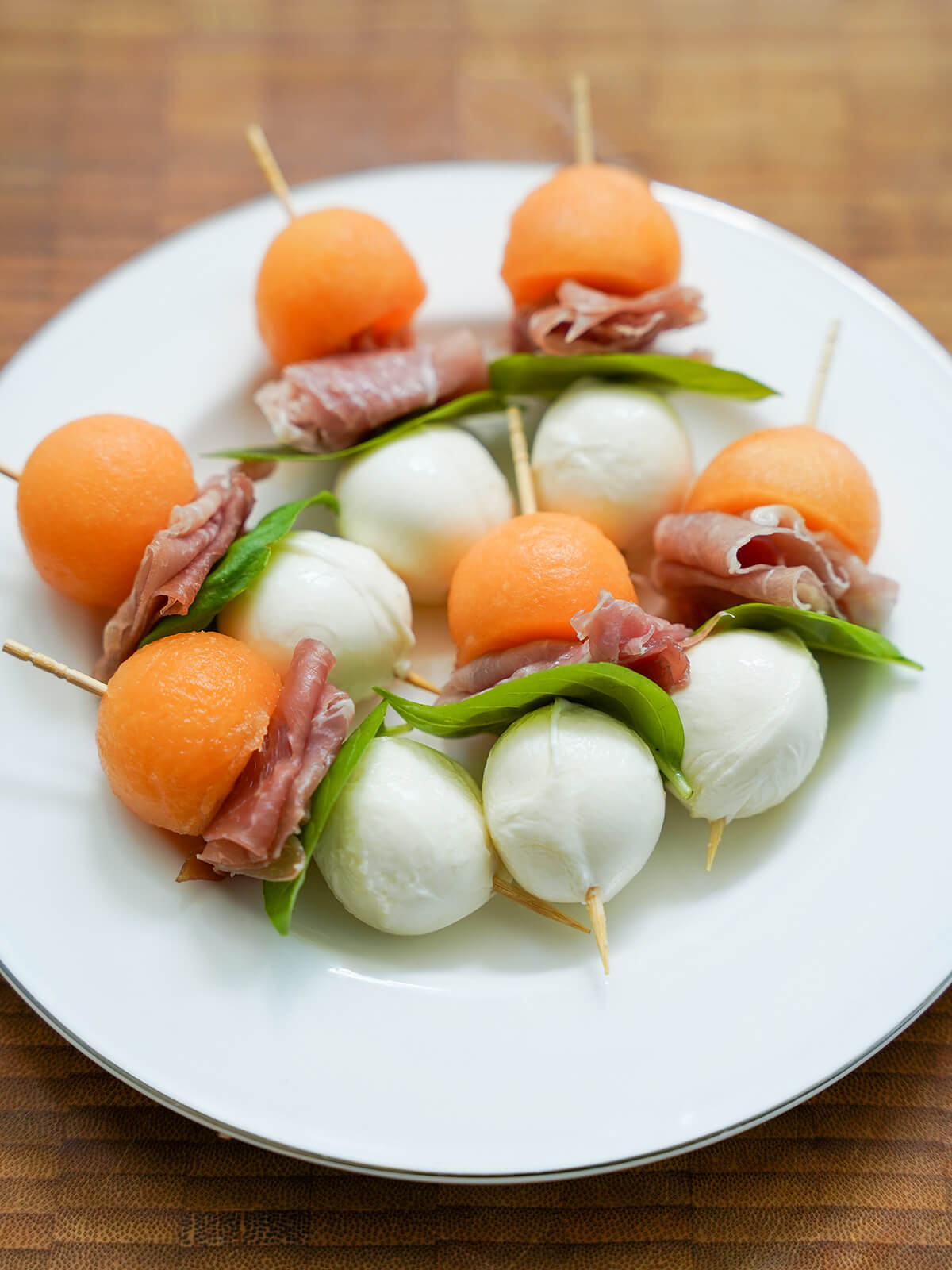 melon and prosciutto skewers on plate before adding glaze.