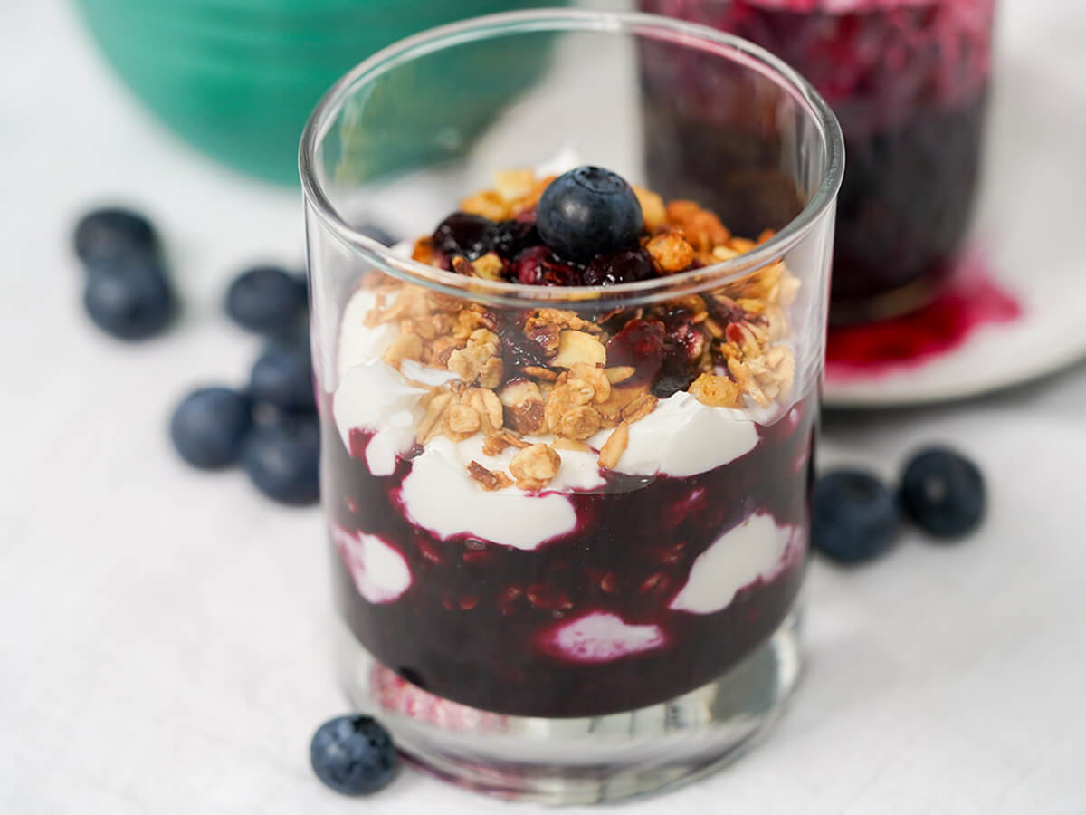 side view of glass of blueberry parfait.