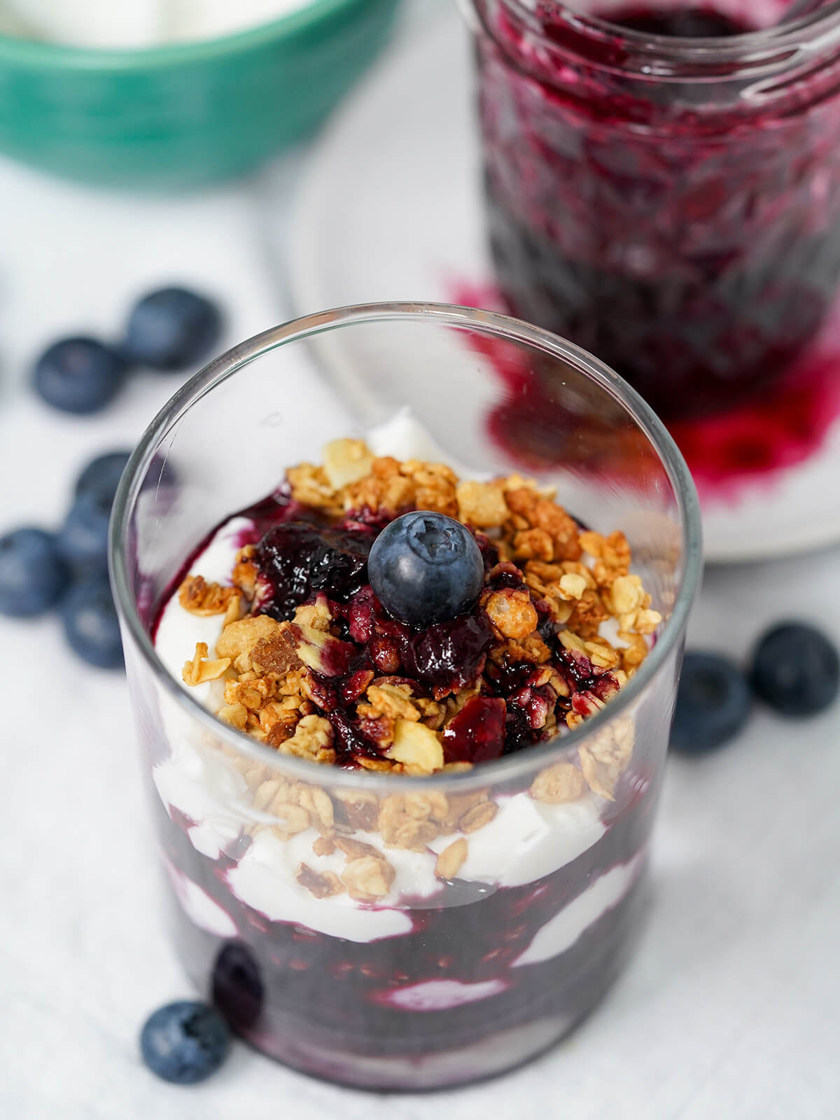 view of blueberry parfait part overhead showing granola on top and layers of yogurt and blueberry.