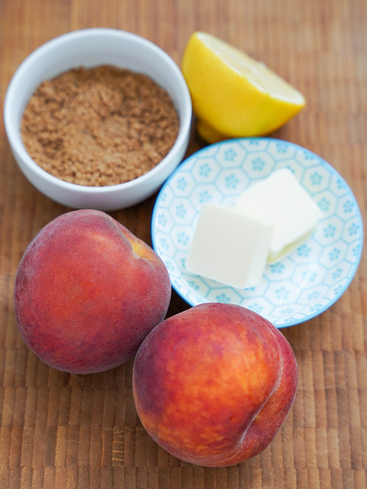 two beaches in front of dishes of butter, brown sugar and half lemon behind.