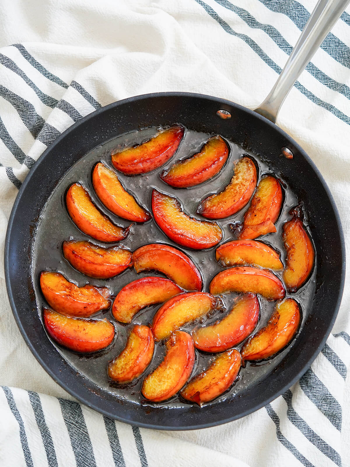 overhead view of skillet of caramelized peaches.