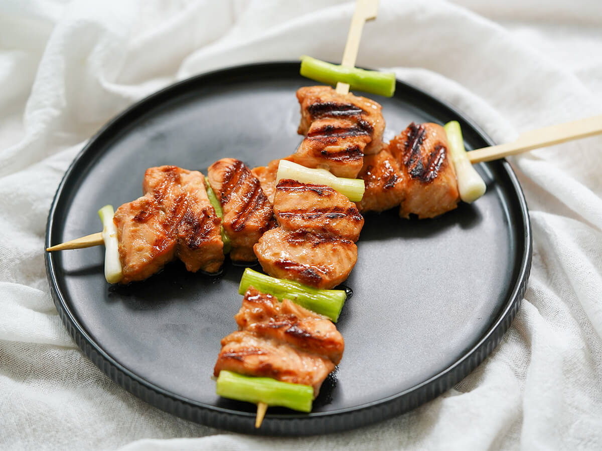 side view of two teriyaki salmon skewers.