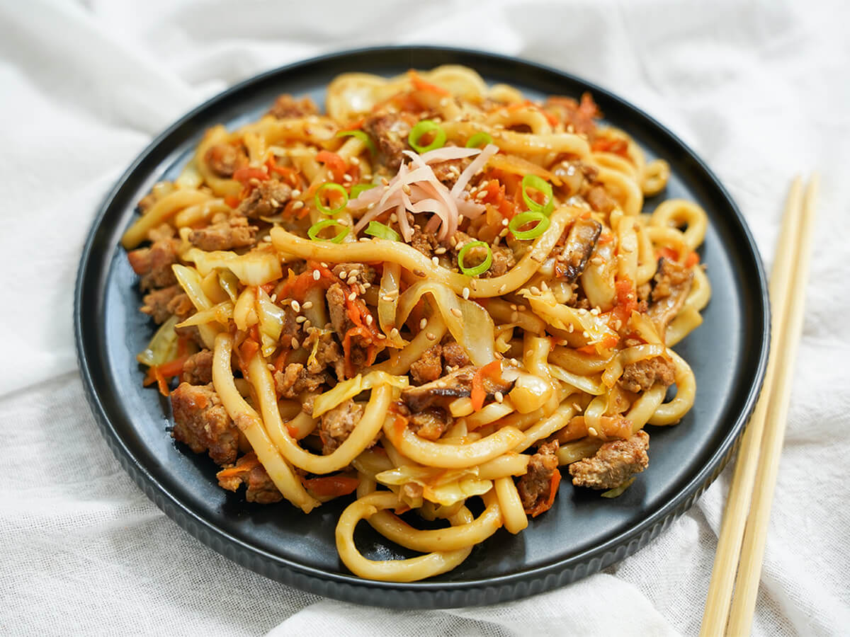 plate of yaki udon with chopsticks to side.