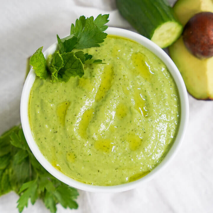 overhead close view of bowl of cucumber avocado gazpacho (green gazpacho).