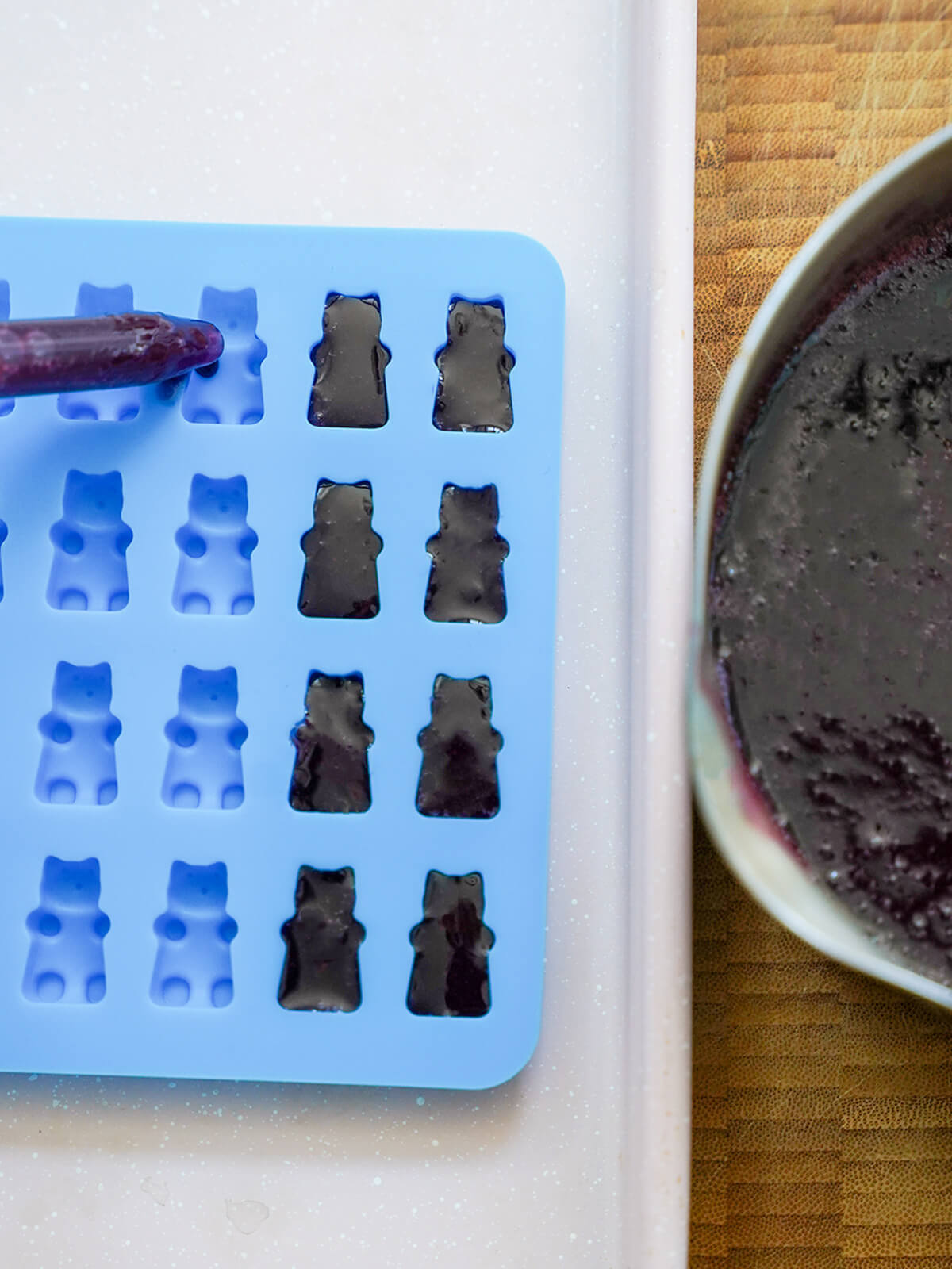 using dropper to fill bear shaped moulds with jelly liquid.