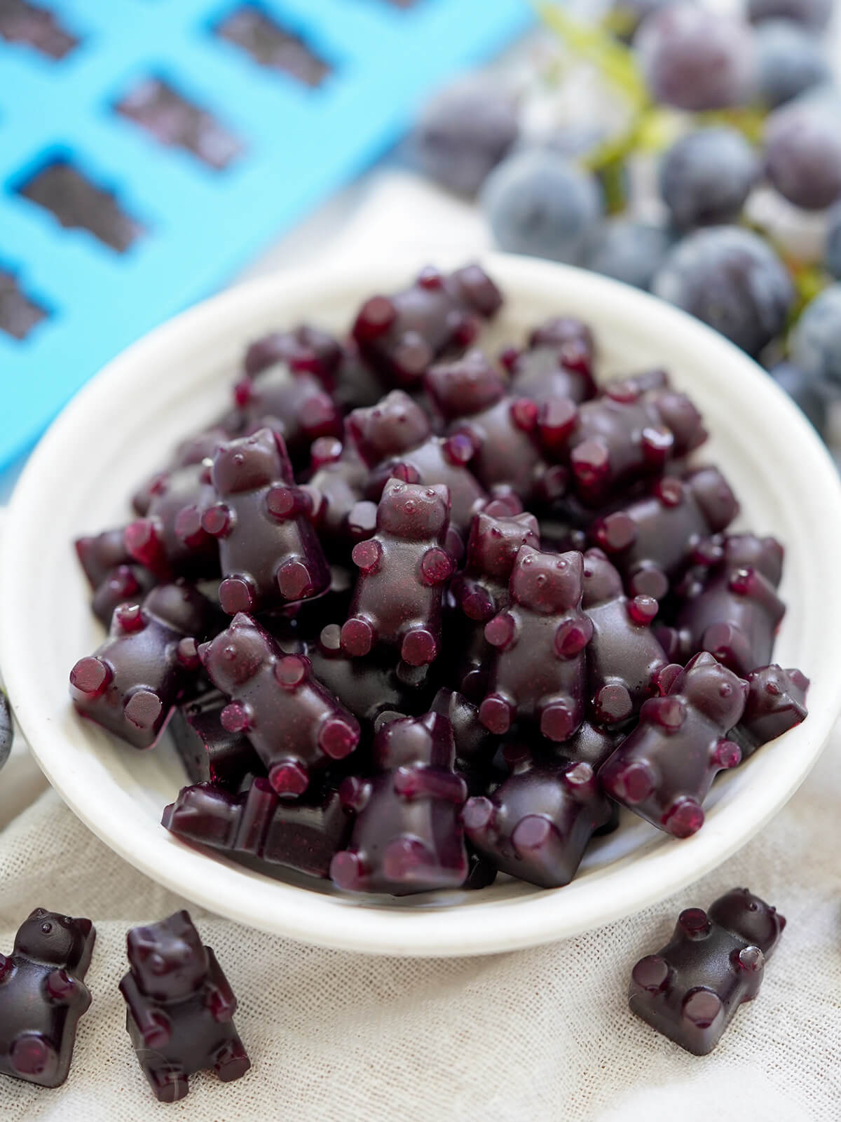 close shot of dish of grape gummy bears with a couple in front.