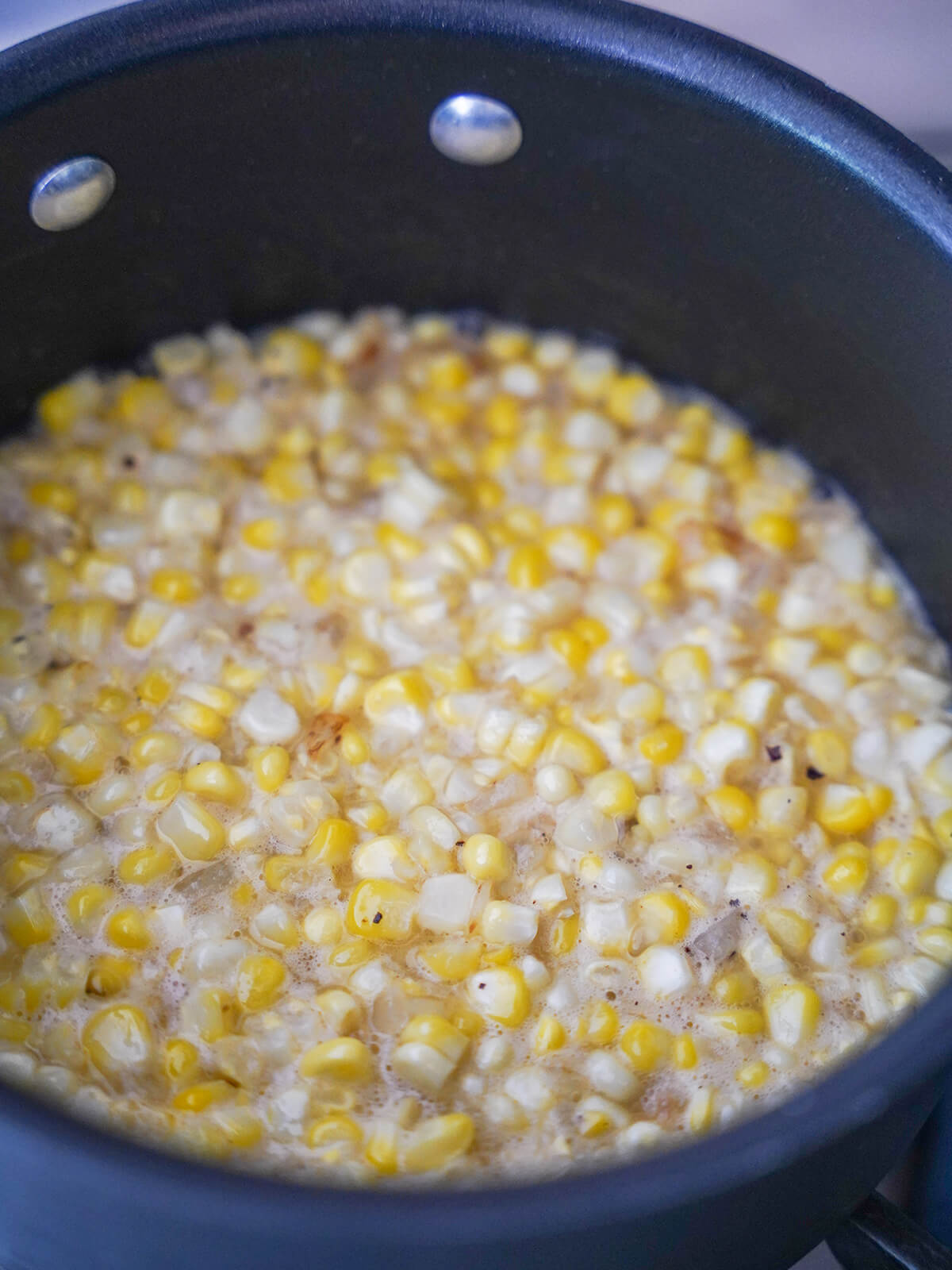 simmering corn kernels in pot.