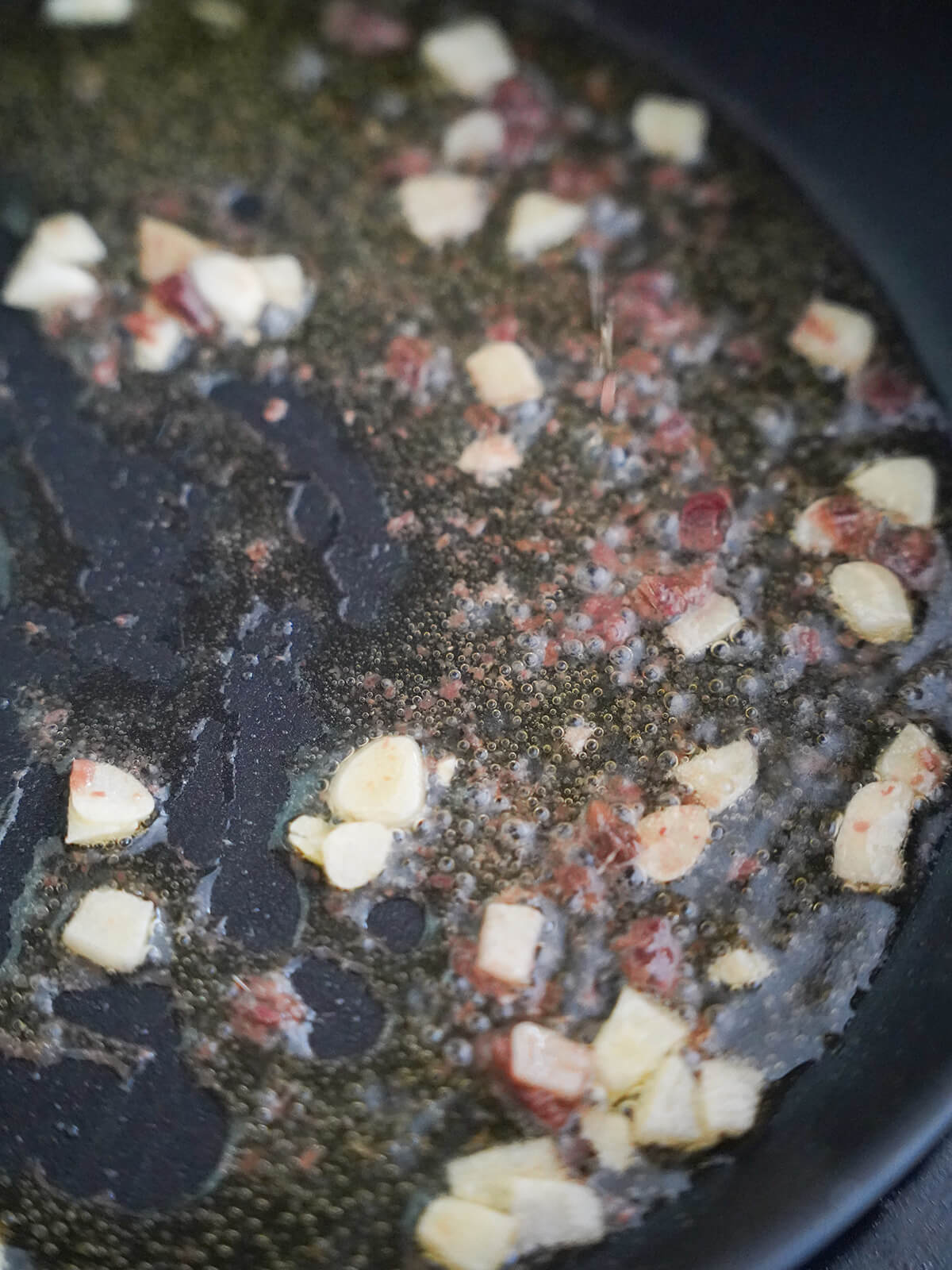 cooking garlic and anchovy for tuna puttanesca cooking garlic and anchovy in olive oil in skillet.