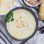 bowl of crab and corn chowder from overhead with spoon below bowl.