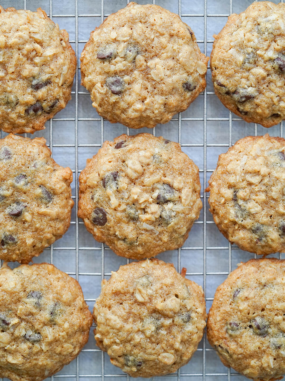 coconut oatmeal chocolate chip cookies in rows on cooling rack.