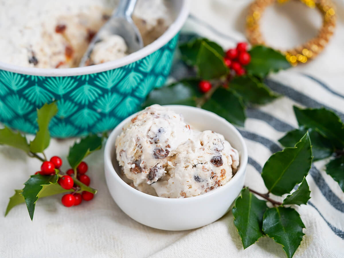 dish with scoops of Christmas pudding ice cream with holly either side.