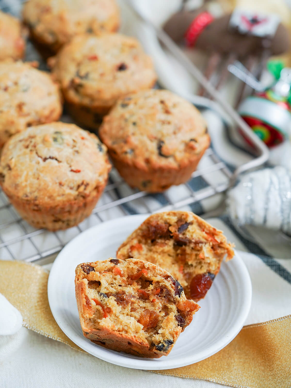 split open Christmas pudding muffin in front of other muffins slightly blurred on rack behind.