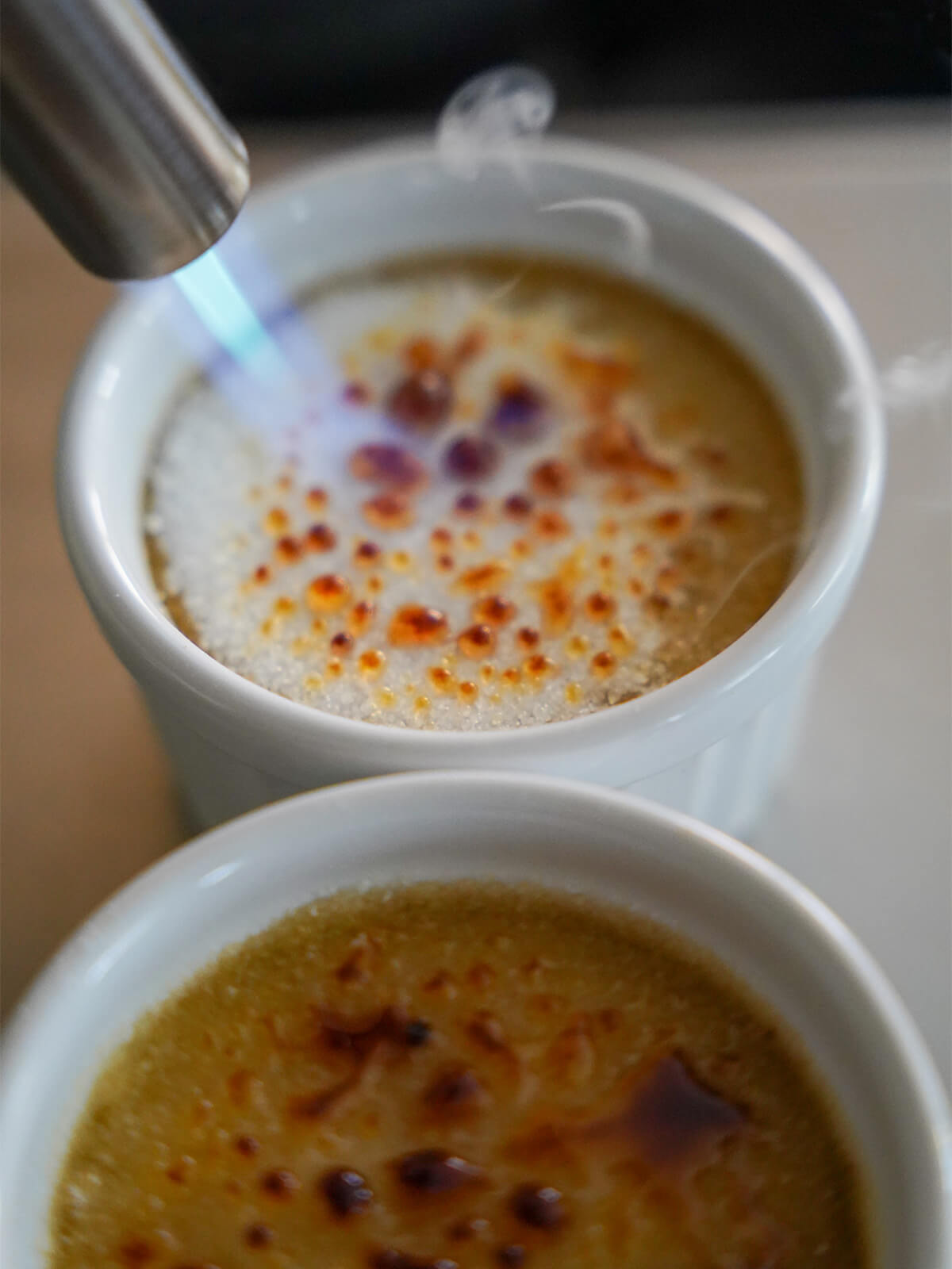 using blowtorch on top of coffee creme brulee.