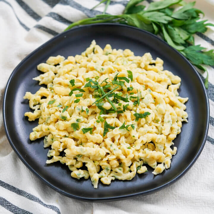 plate of herb spaetzle topped with chopped herbs.
