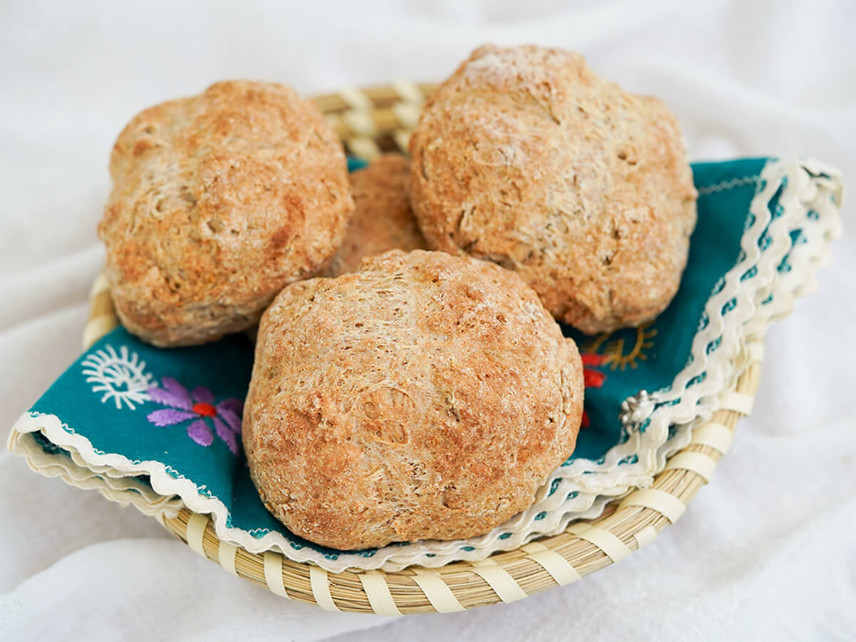 basket lined with decorative cloth filled with Irish soda bread rolls.