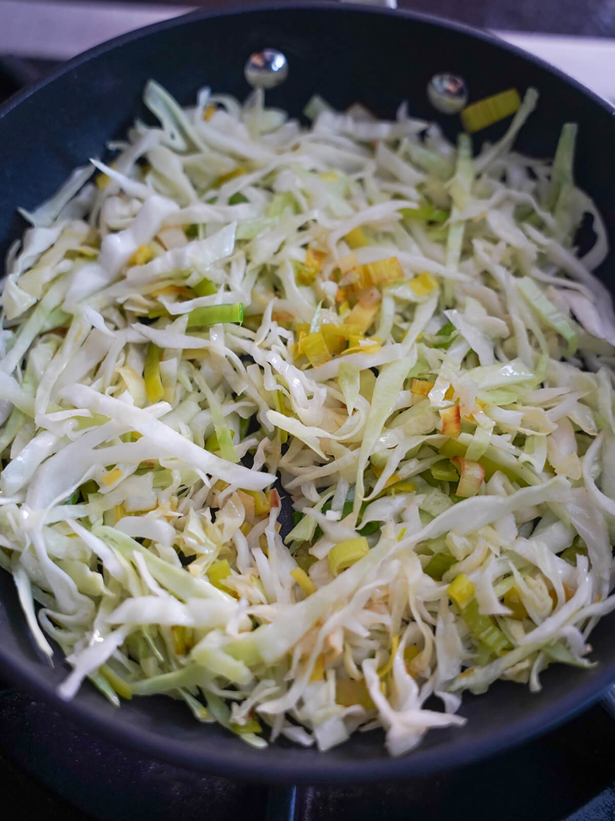 cooking cabbage and leek in skillet.