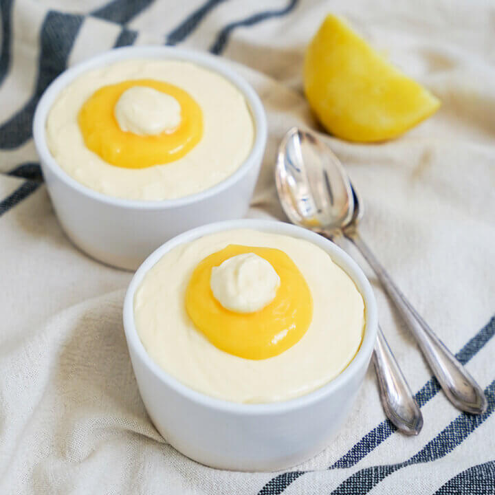 two dishes of lemon mousse with spoons to side.