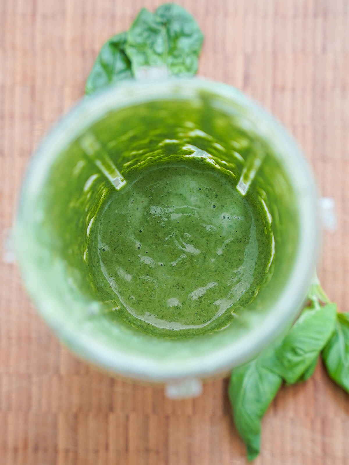 blended sauce for tallarines verdes blender with blended up green sauce inside.