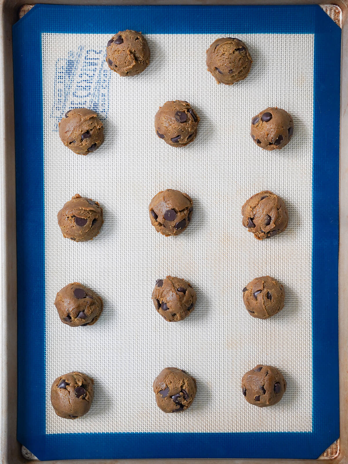 balls of cookie dough on lined baking sheet